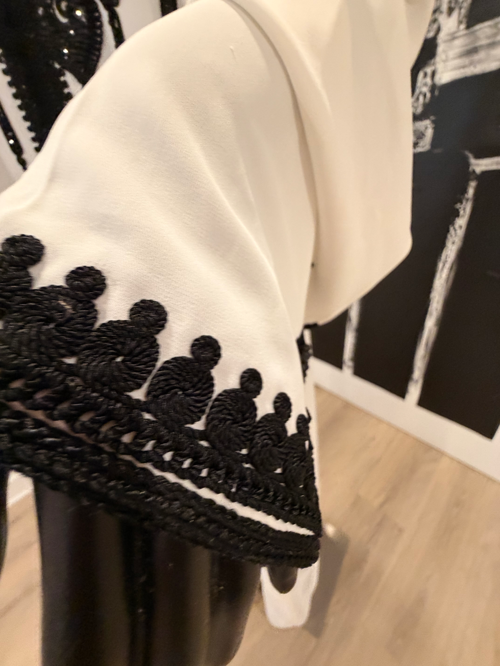 White hooded jellaba with black floral embroidery on chest and cuffs.White hooded jellaba