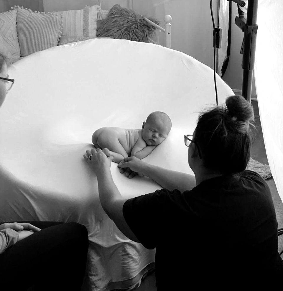 photographer posing newborn for photo