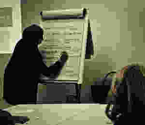 Woman writing on a flip chart during a training session
