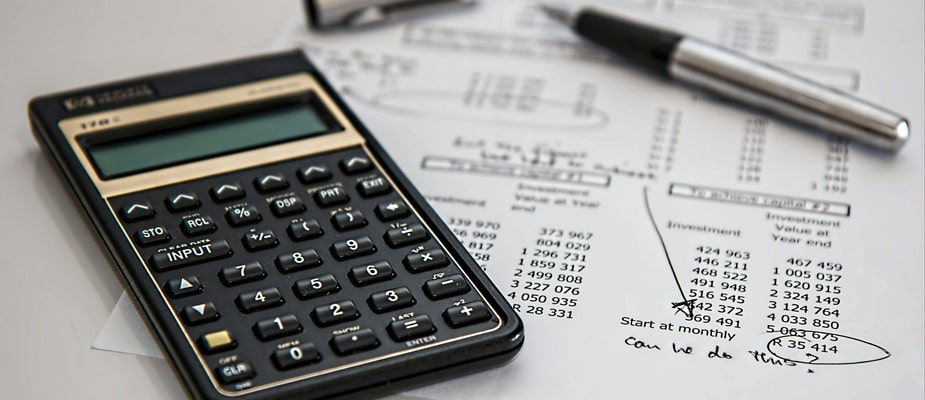 A calculator and budget report with notes in the margins