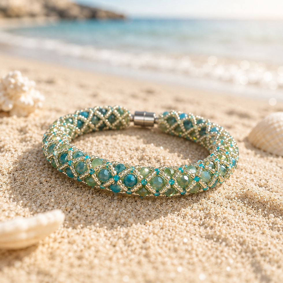 Handwoven Ocean Trellis beaded bracelet featuring turquoise, aqua, and gold beads displayed on sand beside the ocean shore.
