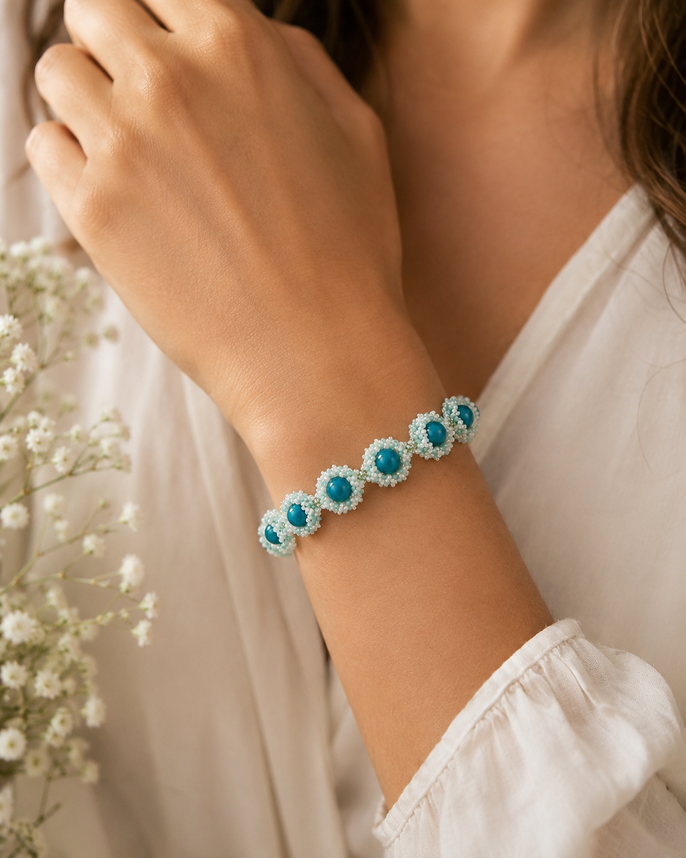 Model wearing the Sea Anemone Beaded Bracelet, a handmade ocean-inspired bracelet in aqua and ivory tones.