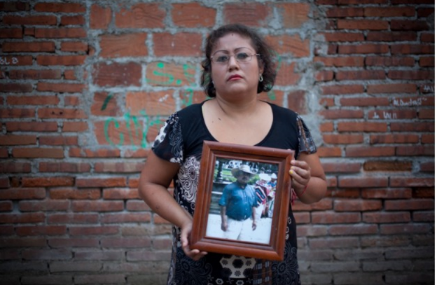 La noche en que desaparecieron a Celedonio Monroy, amenazaron a su esposa Blanca Estela Gómez Larios, quien en la imagen sostiene su retrato. (Mónica González Islas)