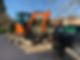 Small orange Spark Contracting digger being towed on a trailer