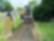 Small digger moving soil to create a path in a graveyard
