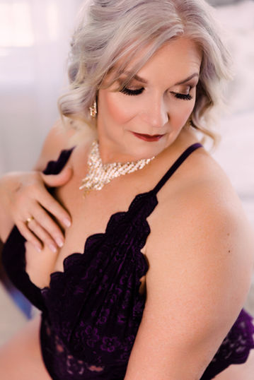 senior boudoir shoot of woman with gray hair and sparkly necklace 