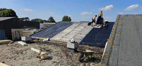 Workers installing a sloped roof on a school building
