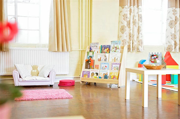 A playroom set up with toys and books for children.