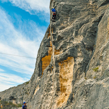 Climber ascending challenging rock face