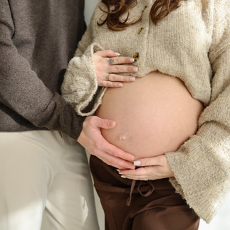 Detail foto van buik en handen van aanstaande ouders