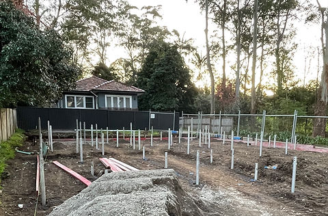 Screw piling used to avoid clash with mature three roots as well as transferring the building foundation load onto the lower stable ground layers by Archbuild custom home builder