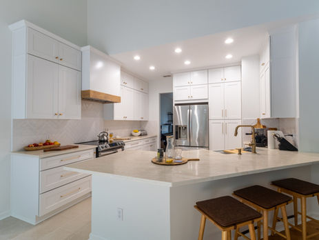 Open-concept white kitchen with island seating and pendant lighting