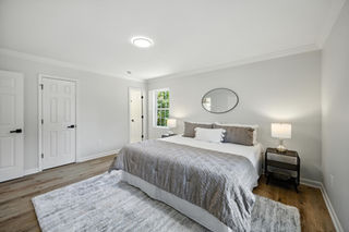 Primary bedroom with new flooring, neutral walls, and updated lighting, South Charlotte renovation.