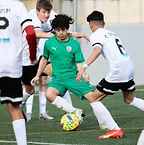 youth soccer player dribbles the ball between 3 defenders
