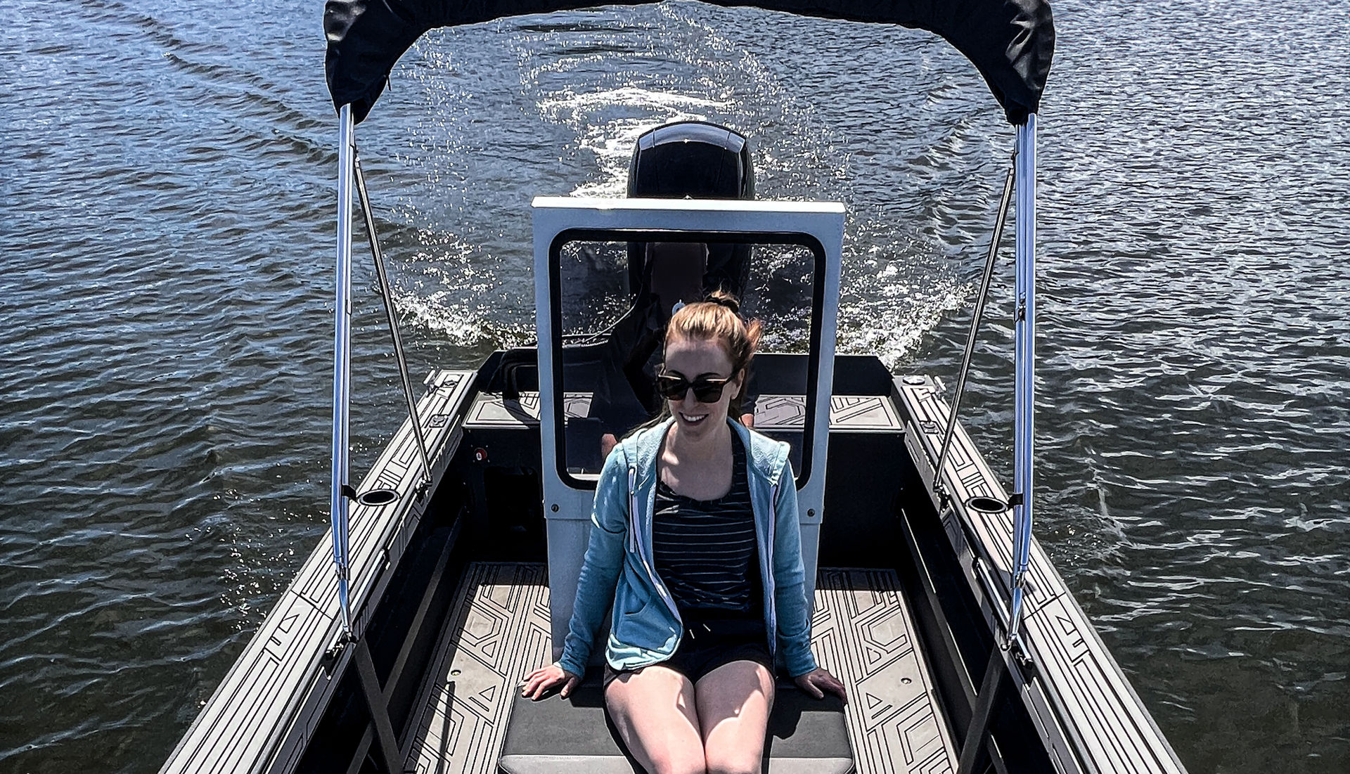 Passenger seated in front of helm aluminum jet boat