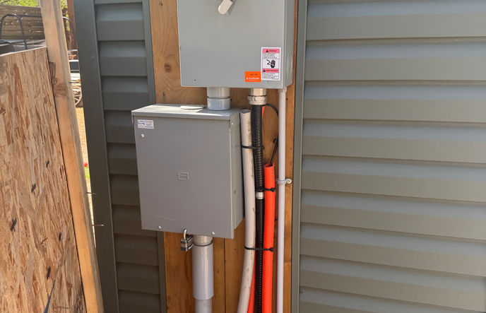 An electrical meter installed on the side of a house.