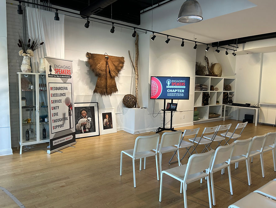Engaging Speakers chapter meeting setup at Altar Chicago, featuring chairs arranged for attendees, a presentation screen reading "Engaging Speakers", a banner highlighting core values, and curated art and decor in a modern and spiritual-like space
