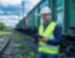 Pracownik kolei z tabletem podczas inspekcji wagonów – cyfrowe zarządzanie taborem i monitoring stanu technicznego.