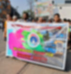 A public gathering outside the tram depot. People are holding a large banner that reads “Calcutta Tram Users Association. We Demand Trams for Women’s Safety.”