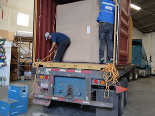 Opération de déménagement international avec du personnel spécialisé déchargeant un camion, illustrant des services d’emballage professionnel, de coordination logistique et de relocalisation internationale sécurisée par Logimpex.