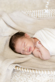 Newborn baby sleeping in Moses basket during lifestyle newborn session.