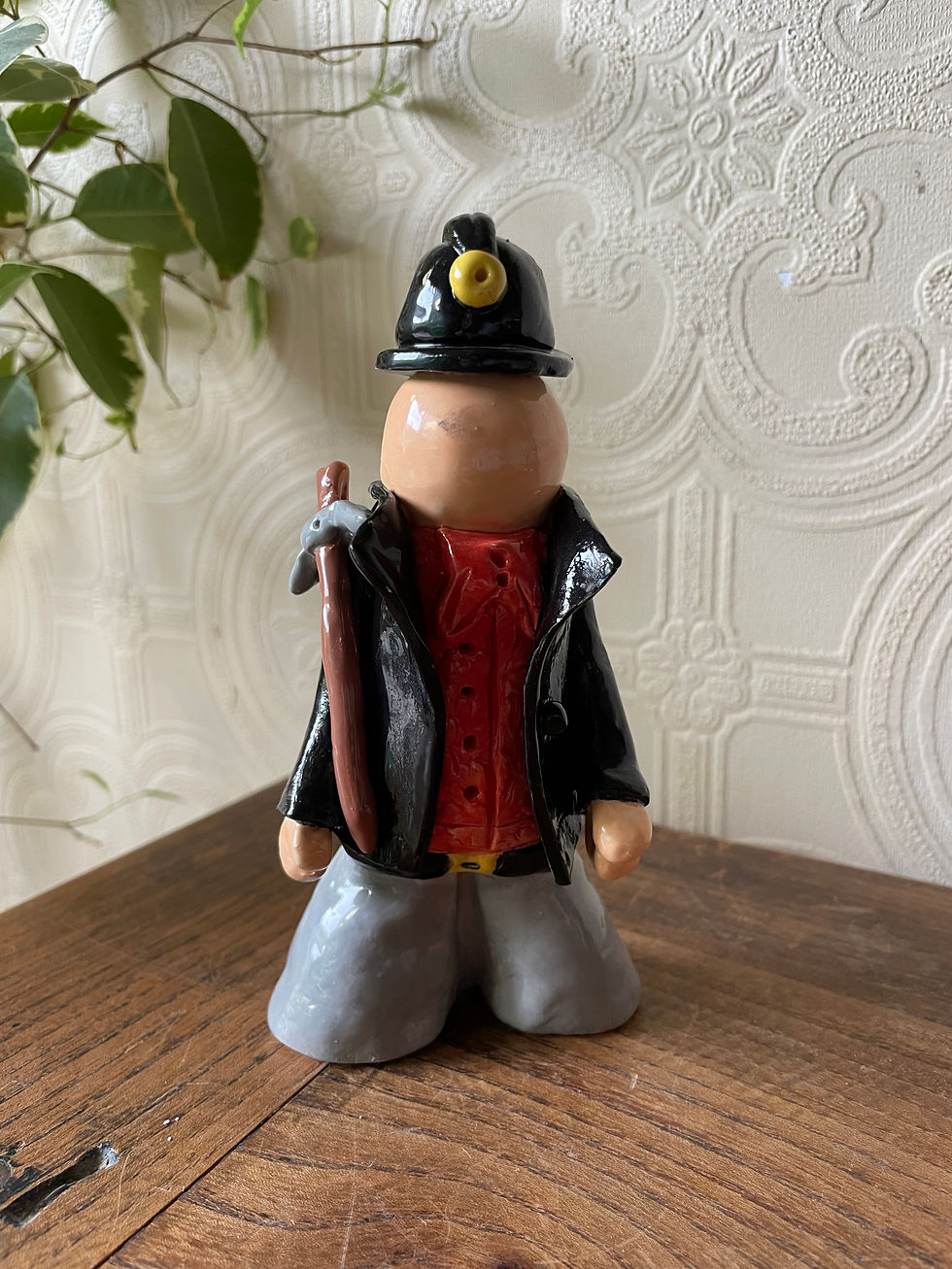 Close-up of a handmade Welsh miner ceramic sculpture with textured clay details.