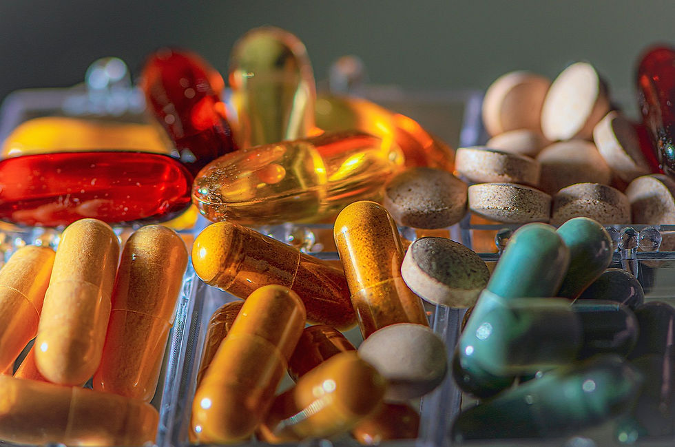 Close-up of various pharmaceutical pills, vitamins, and dietary supplements in different shapes and colors.