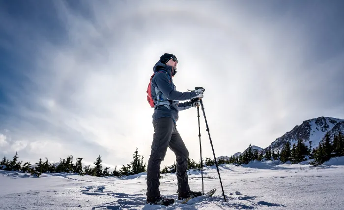 person snowshoeing in a helicopter accessible area during winter in alaska