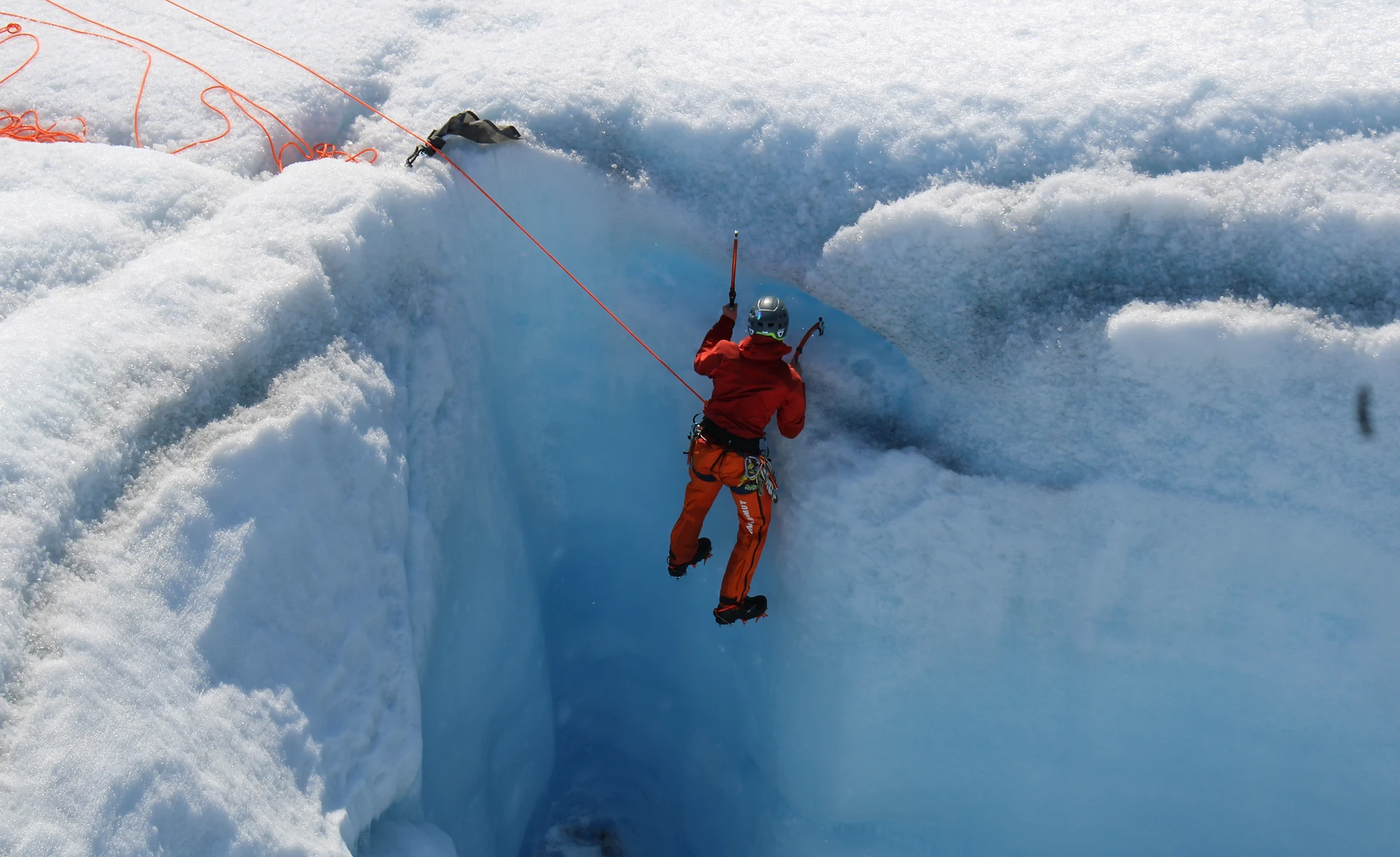 man ice climbing on a glacier in alaska