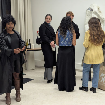 Artist PC Yashaswini explaining stuff to a visitor in gallery in Paris