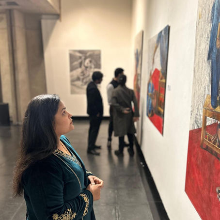 Employee taking a reflective moment in an office surrounded by calming artwork designed to support mental wellbeing and reduce stress.