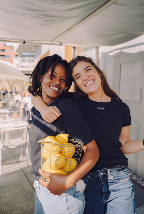 Employees at Kumi resturant in Oslo holding some fruit and smiling
