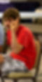 headshot of man in red shirt holding the 2-finger peace sign up