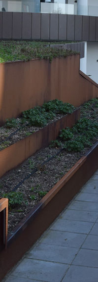 Byrumsmiljø og -passage fremstillet i Corten stål.