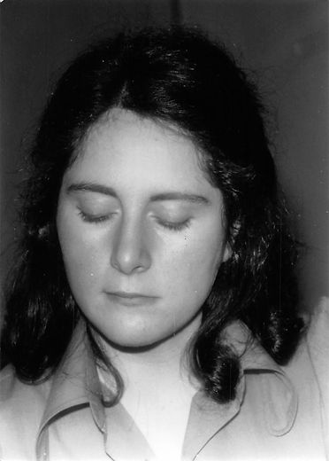 Black and white photo of Evelyne posed thoughtfully as a young woman