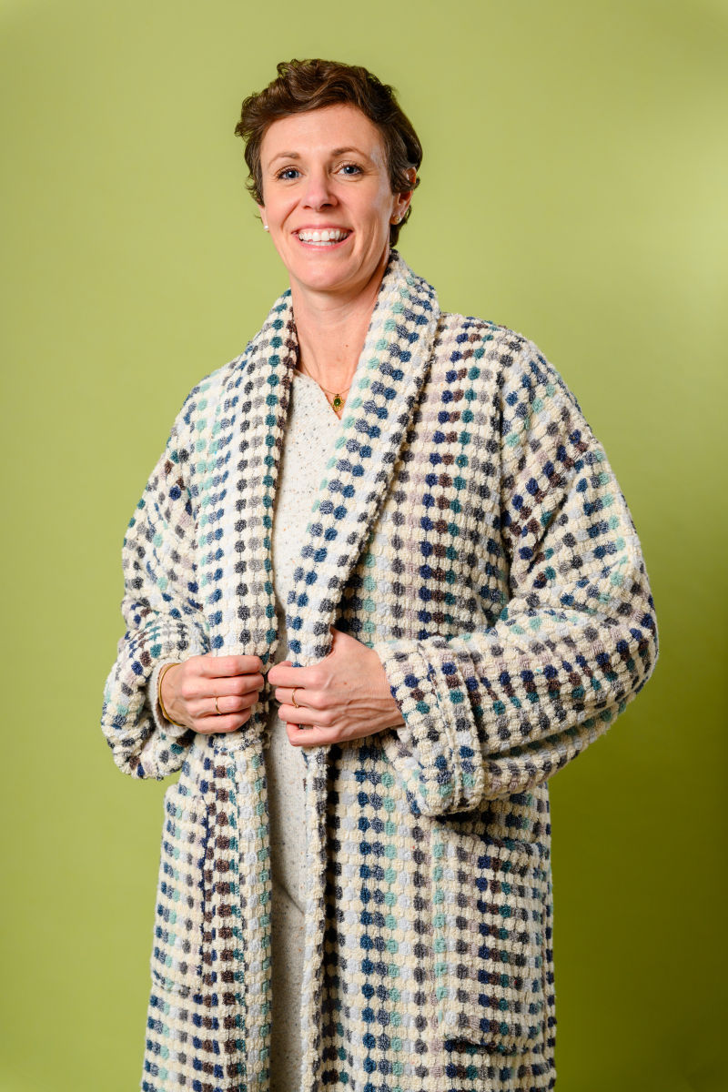 person wearing plush terry cloth robe with light colored checkers - zoom view
