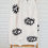 Thumbnail: Cream Turkish towel with black evil eye outline laying on a ladder