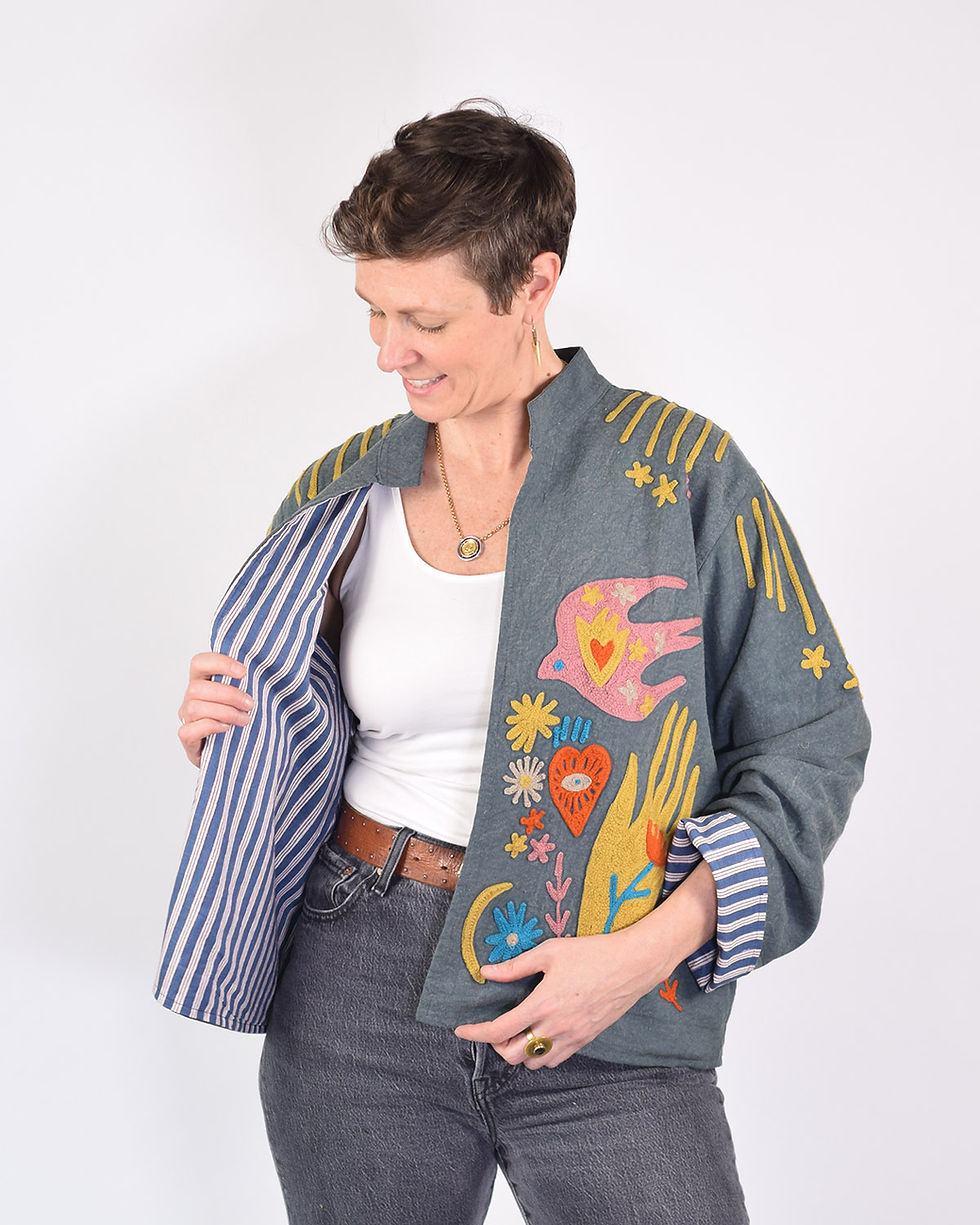 Thumbnail: person wearing a blue lightweight jacket with colorful icons embroidered on it