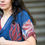 Thumbnail: Person wearing a blue kaftan with red lotus' printed on it
