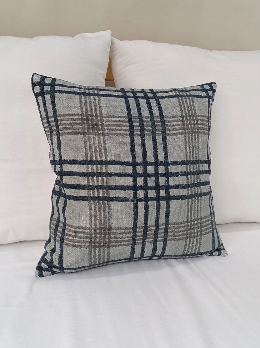 grey and black checkered pillow on a bed