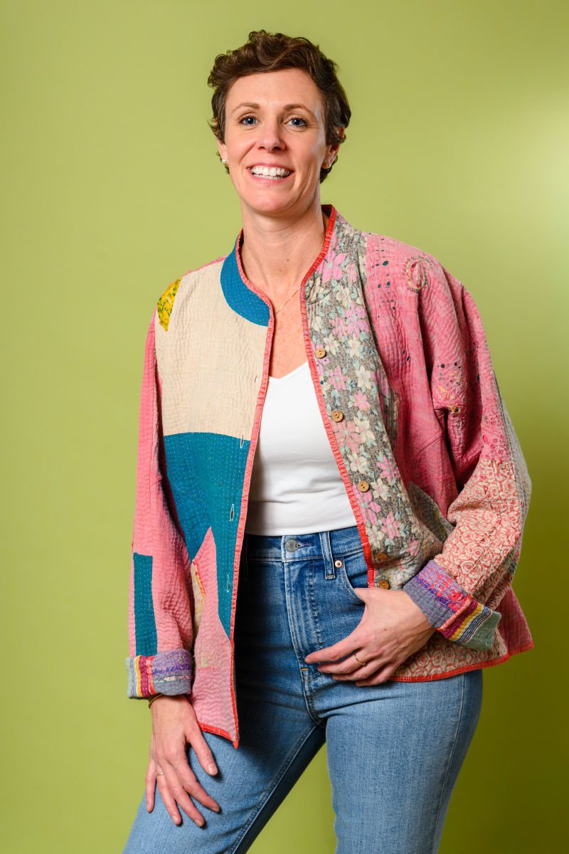 Person wearing a colorblock jacket made from repurposed quilts