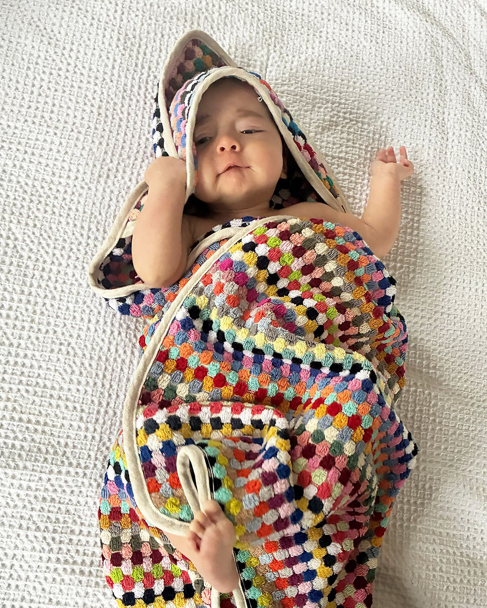 cute baby wrapped in a colorful terry cloth towel