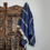 Thumbnail: Navy Turkish cotton blanket hanging over the side of a closet
