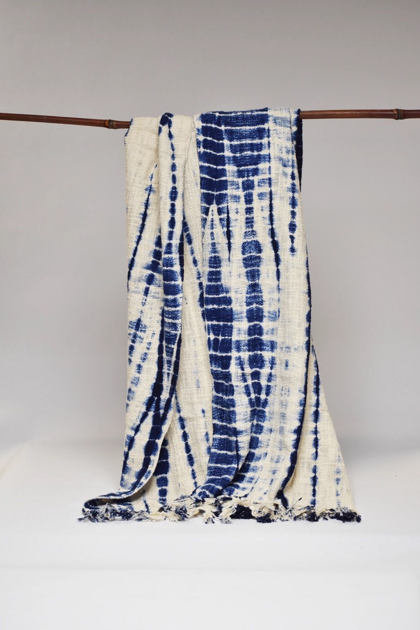 Tie dyed blue and cream blanket hanging from a string