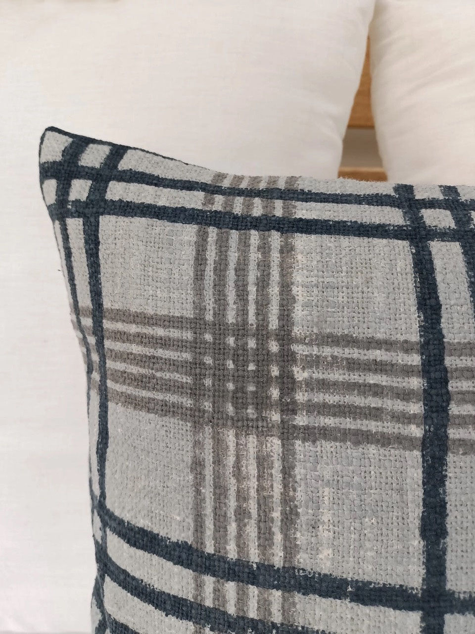 grey and black checkered pillow on a bed