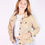Thumbnail: girl wearing a light colored button up jacket made from quilts