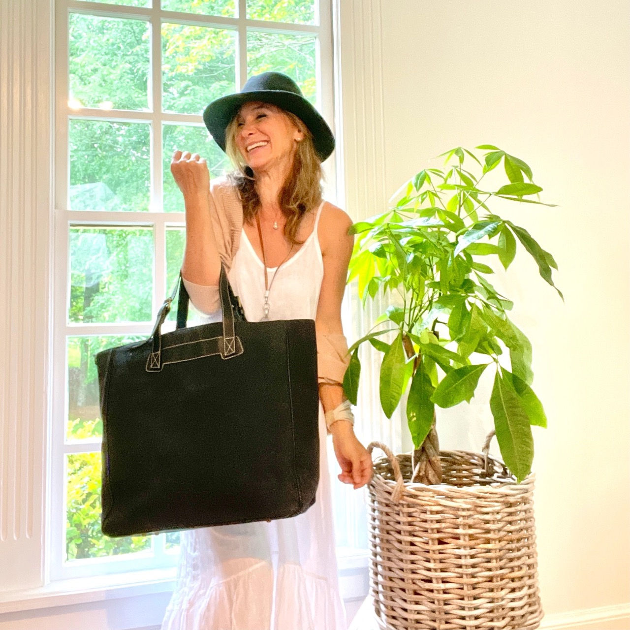 Person carrying a large black canvas tote bag.