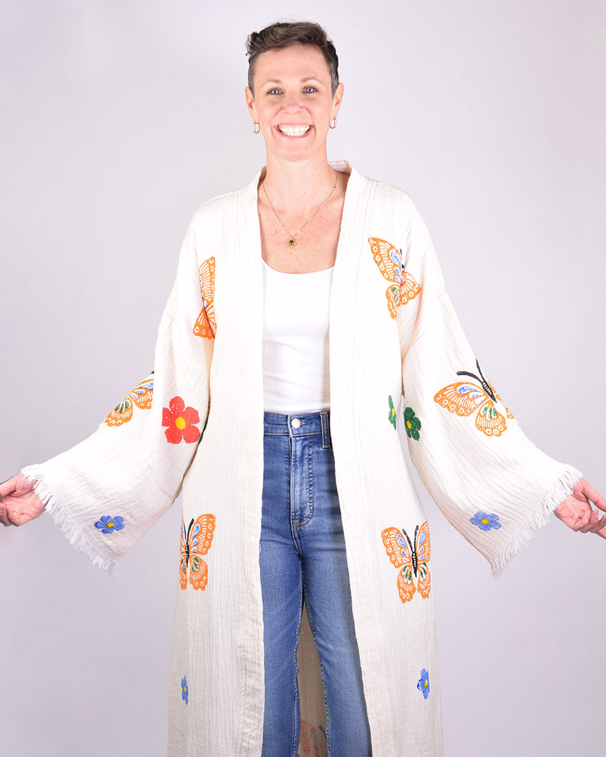Person in cream colored cotton kimono painted with butterflies and flowers - front view