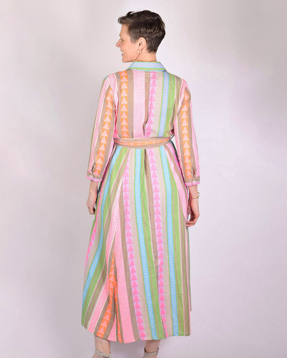 person wearing shirt dress made of a green and bright pink woven fabric - back view