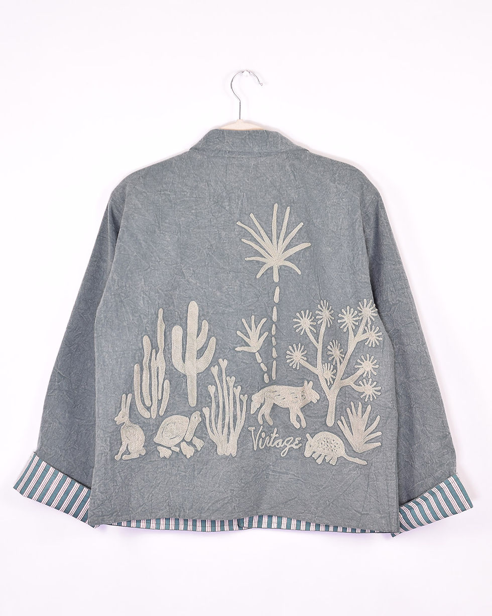 green canvas jacket with desert icons embroidered on it - back view